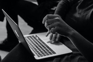 Black and white photo of person using laptop